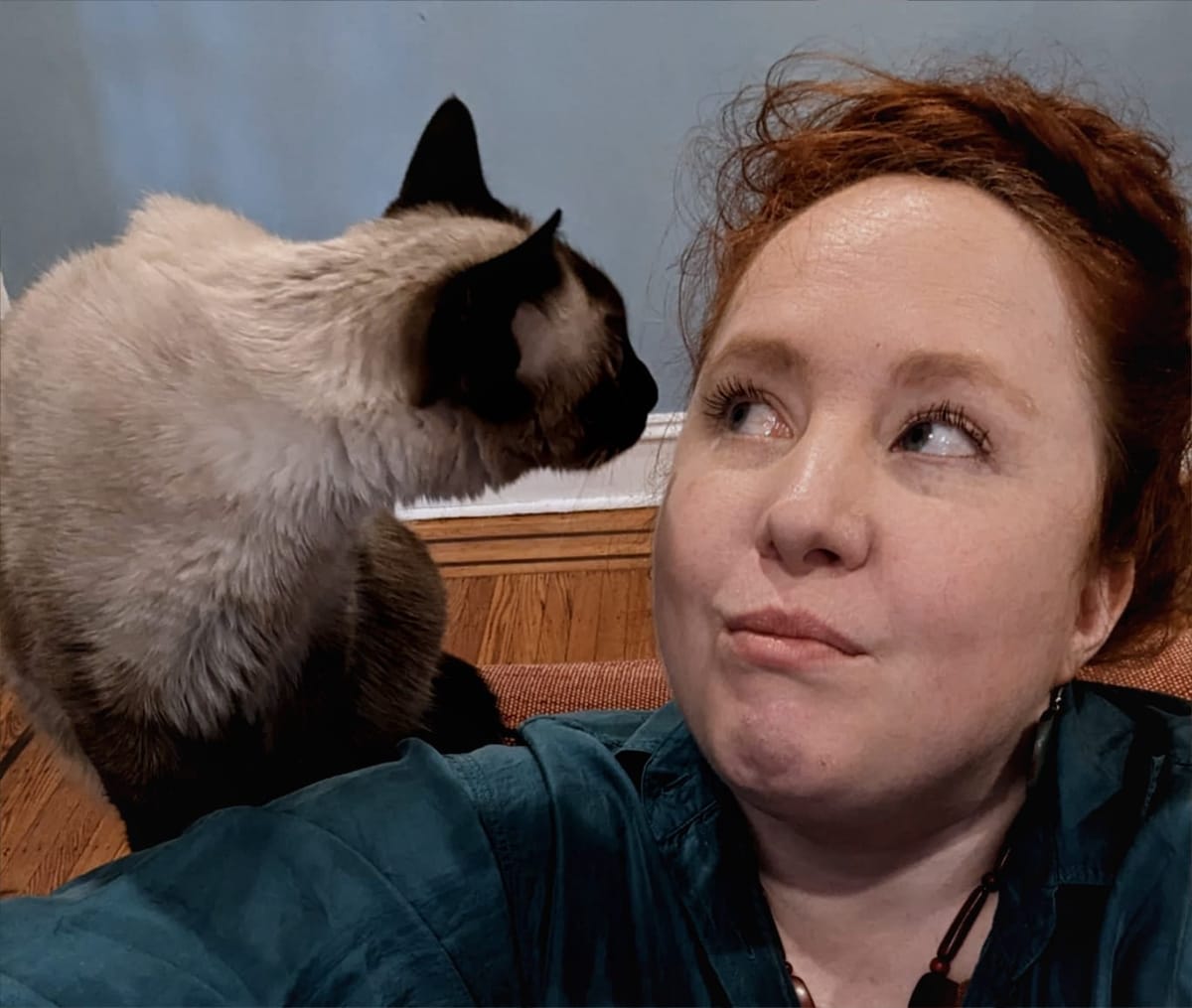 Sophie makes a kissy face at our terrible cat, Barnacle