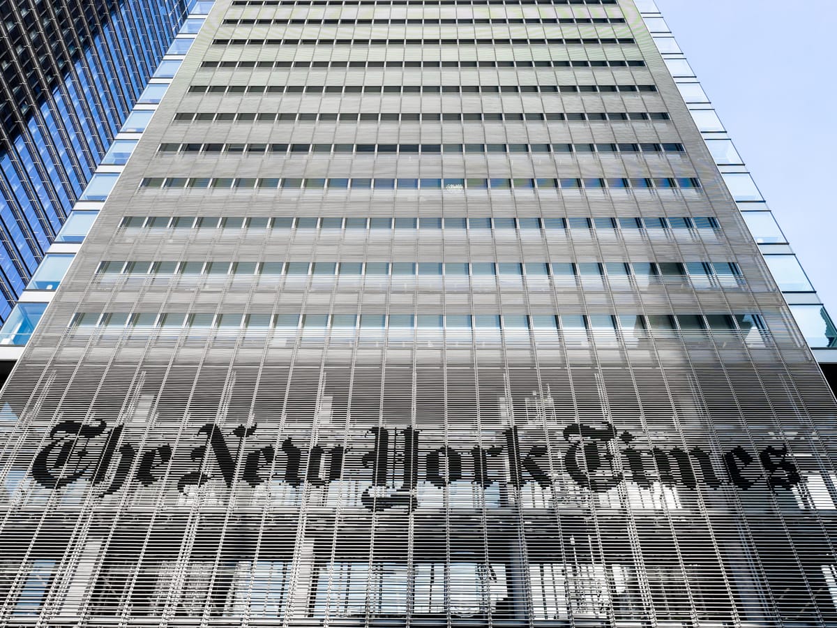 A picture from street level looking up at The New York Times building in Times Square with its logo prominent and center